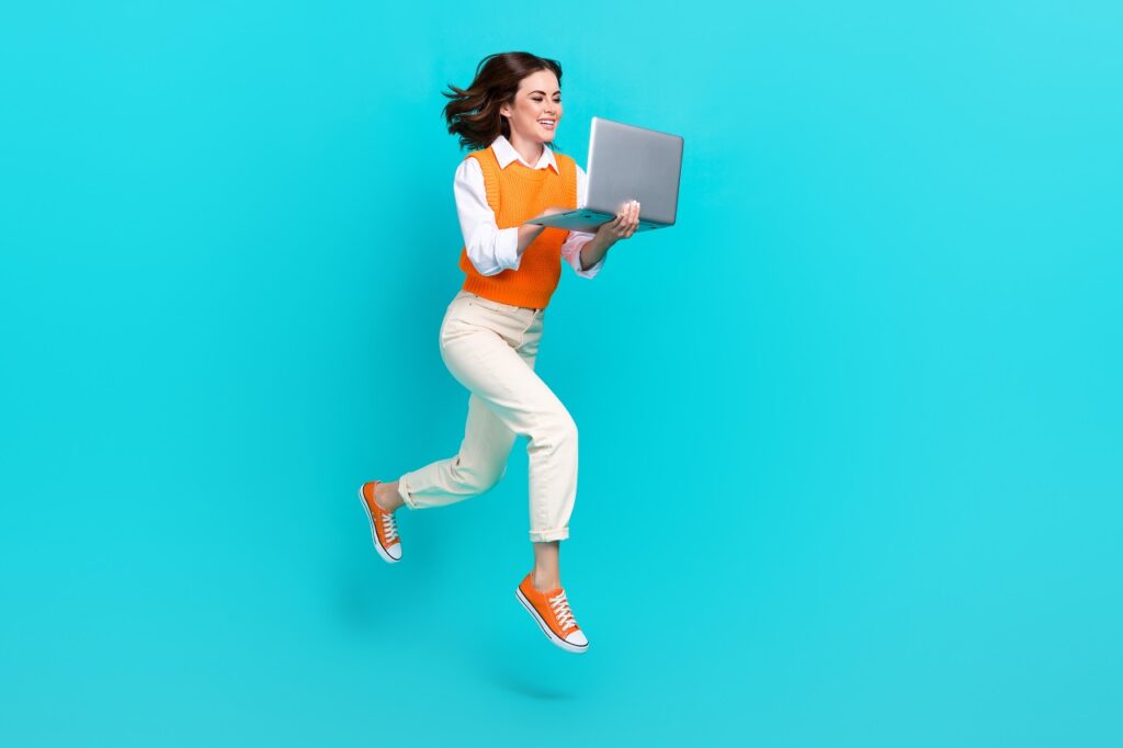 Will AI replace digital marketing Full body photo of attractive programmer office worker girl hold netbook order online shopping isolated jump isolated on blue color background.