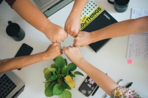 Building Allies: Men’s Roles in Advancing Gender Equality in Tech team fists together office workplace
