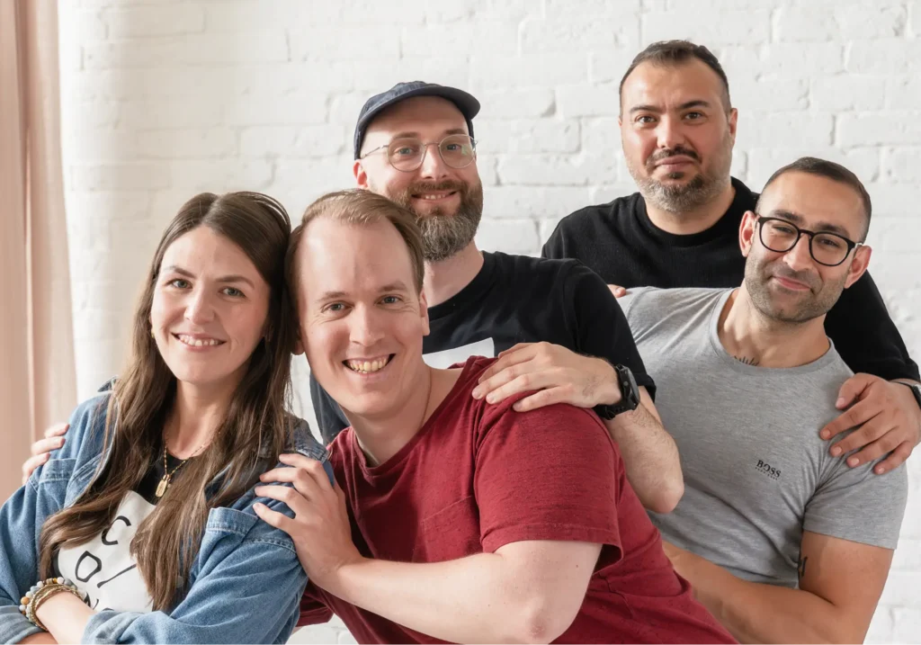 Group of 5 coworkers posing together.